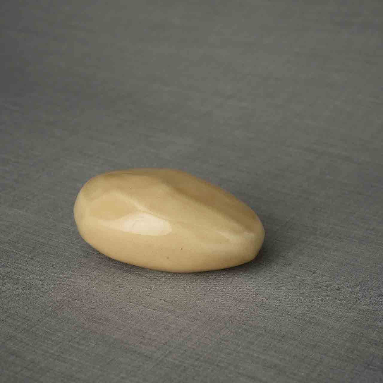 Pebbles Ashes Keepsake Urn in Light Sand Facing Right Dark Background
