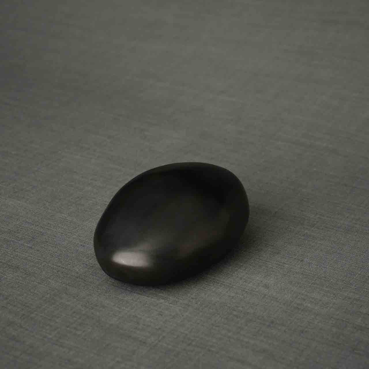 Pebbles Ashes Keepsake Urn in Matte Black Facing Left Baackground