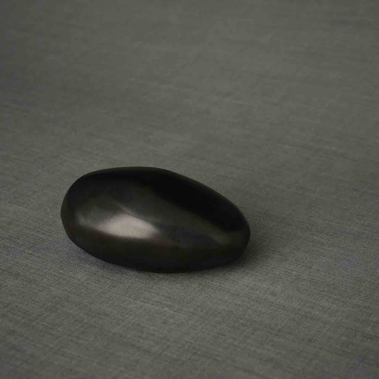 Pebbles Ashes Keepsake Urn in Matte Black Facing Right Dark Background