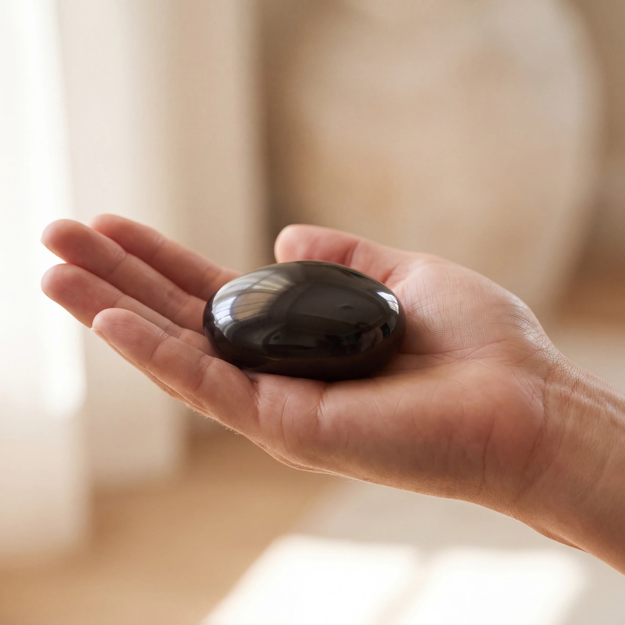 Pebbles-Small-Urn-for-Ashes-in-Glossy-Black-In-the-Palm