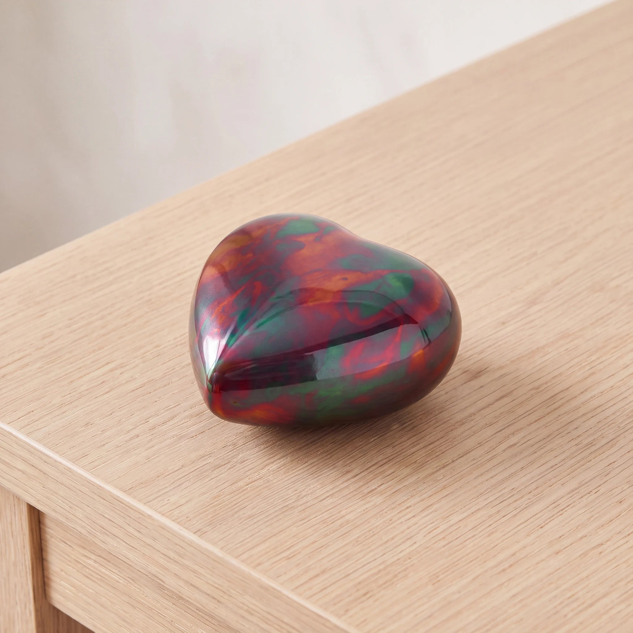 Raku-Metal-Heart-Keepsake-Urn-for-Ashes-in-Red-and-Green-On-Oak