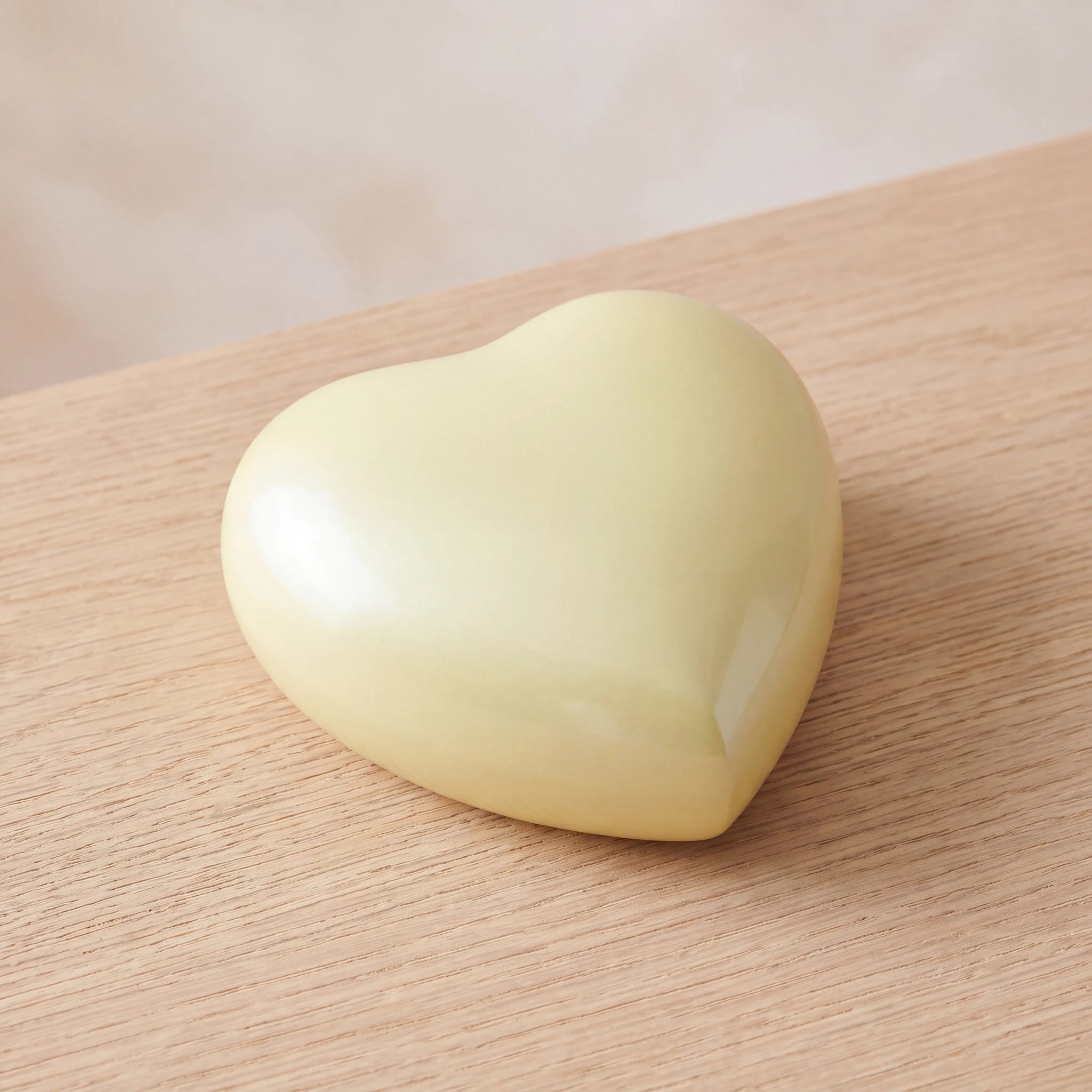 Satori-Metal-Heart-Keepsake-Urn-for-Ashes-in-Pearl-Yellow-On-Oak