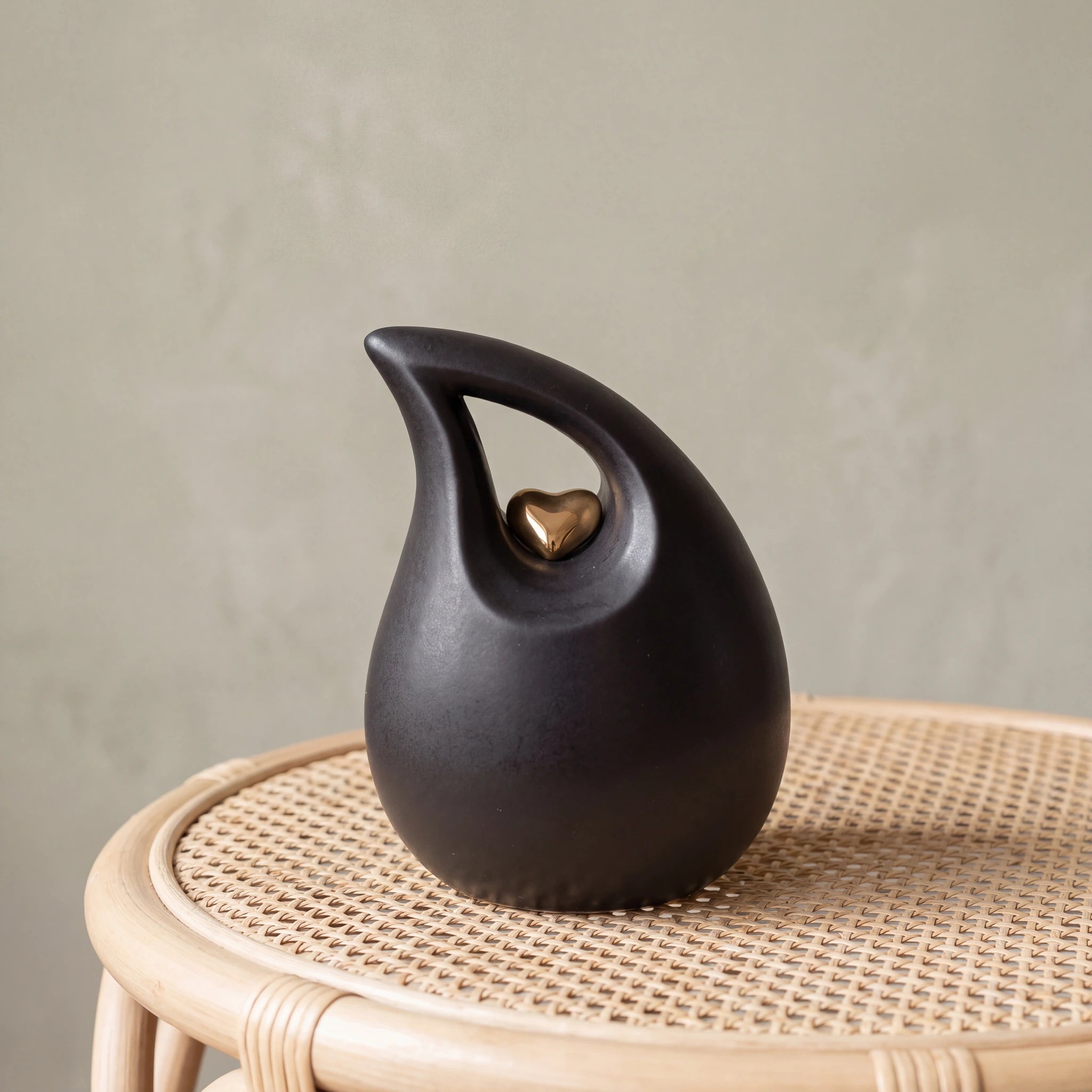 Teardrop-Heart-Small-Urn-for-Ashes-in-Black-and-Gold-Cane-Table