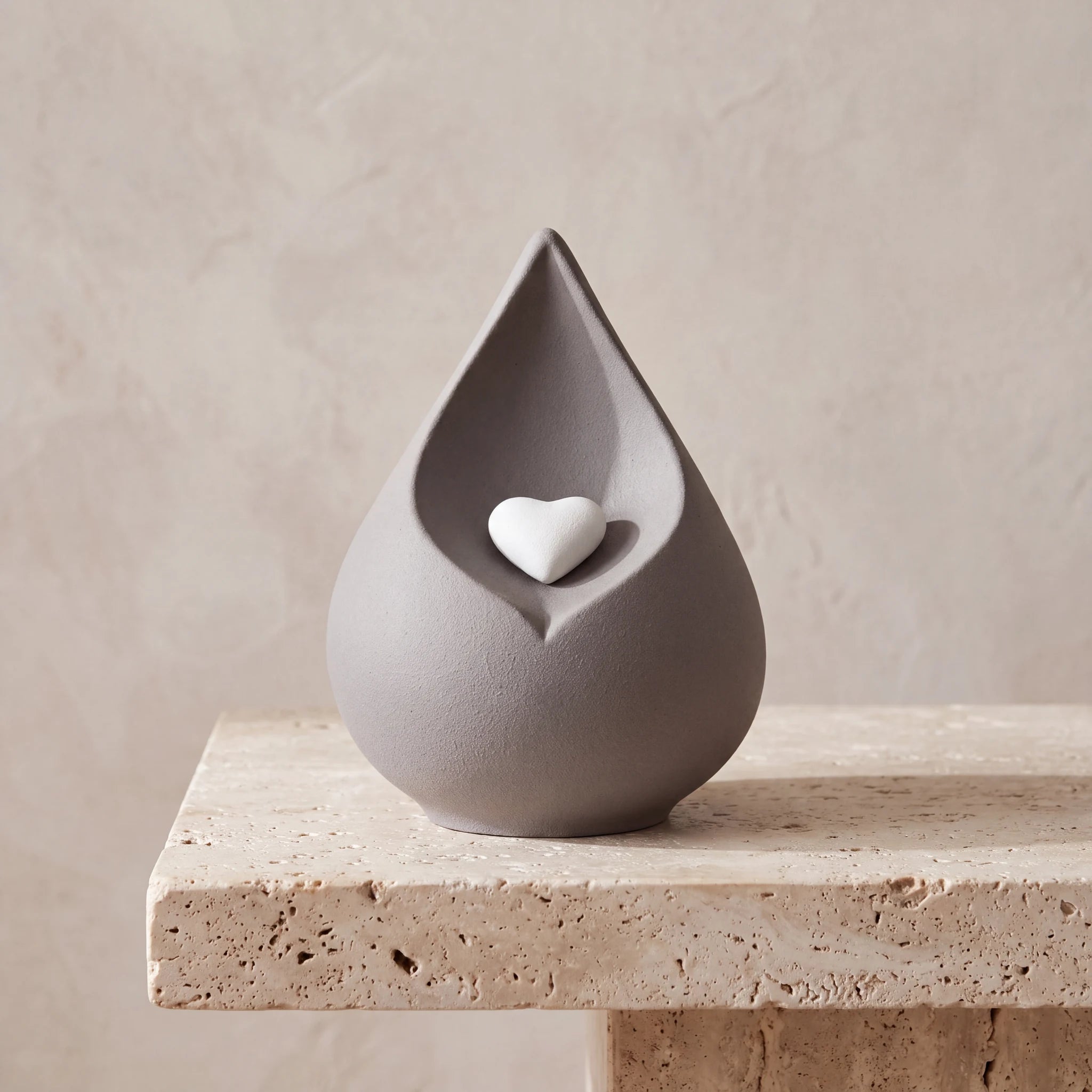 Teardrop-Medium-Urn-for-Ashes-with-Heart-in-Grey-Travertine-Ledge