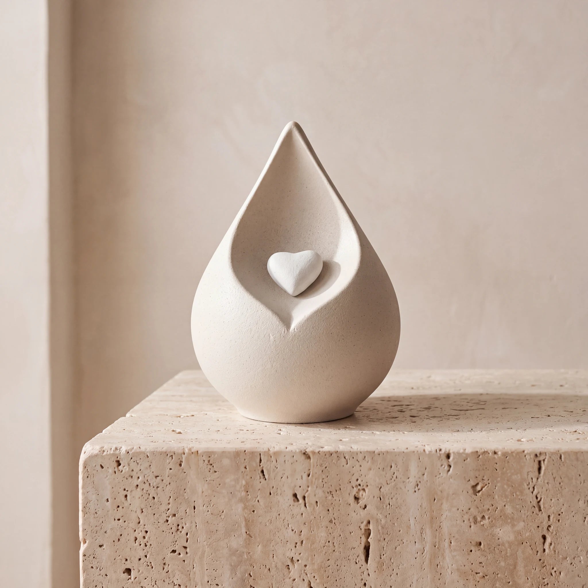 Teardrop-Small-Urn-for-Ashes-in-with-Heart-in-Light-Beige-Travertine-Ledge