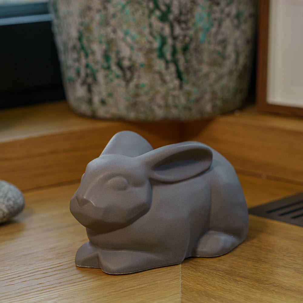 Rabbit Urn For Ashes Matte Grey On Cupboard Front Left Higher Angle