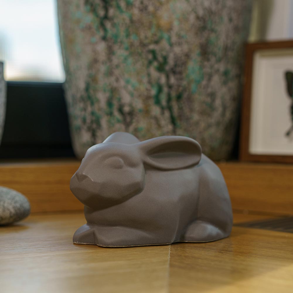 Rabbit Urn For Ashes Matte Grey On Cupboard Front Left