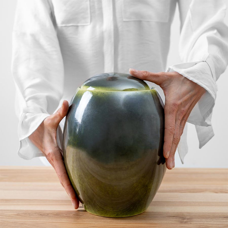 Deep Green Modern Cremation Urn for Ashes Being Held