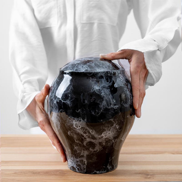 Freckled Classic Cremation Urn for Ashes Black Being Held