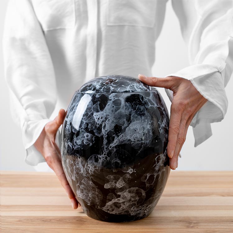 Freckled Modern Cremation Urn for Ashes Black Being Held