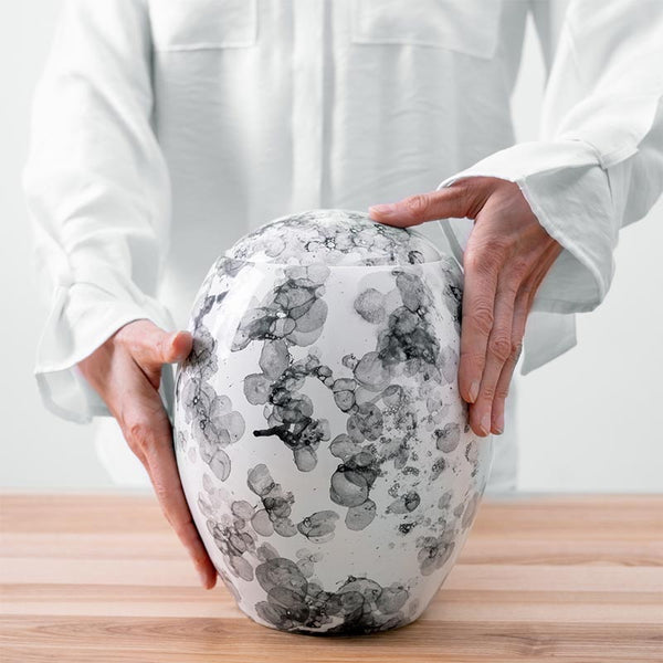Freckled Modern Cremation Urn for Ashes White Being Held