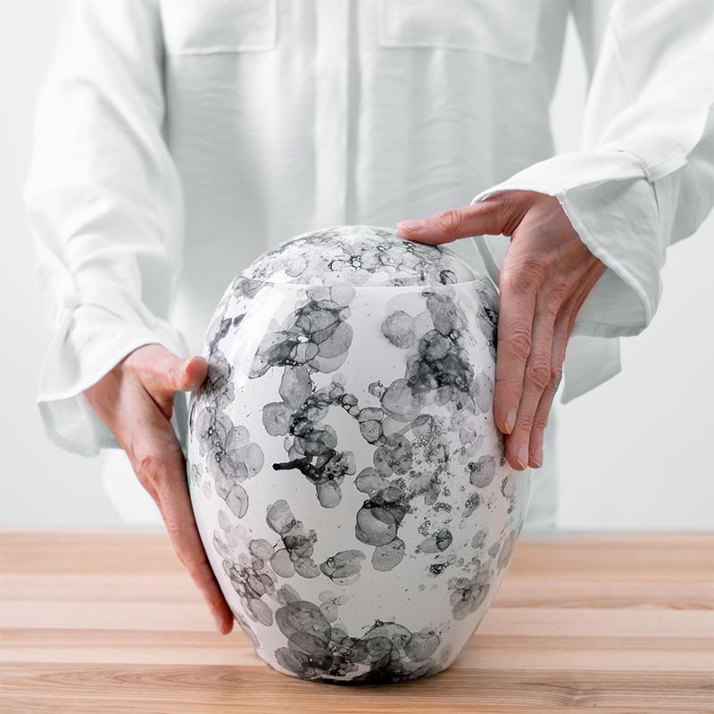 Freckled Modern Cremation Urn for Ashes White Being Held