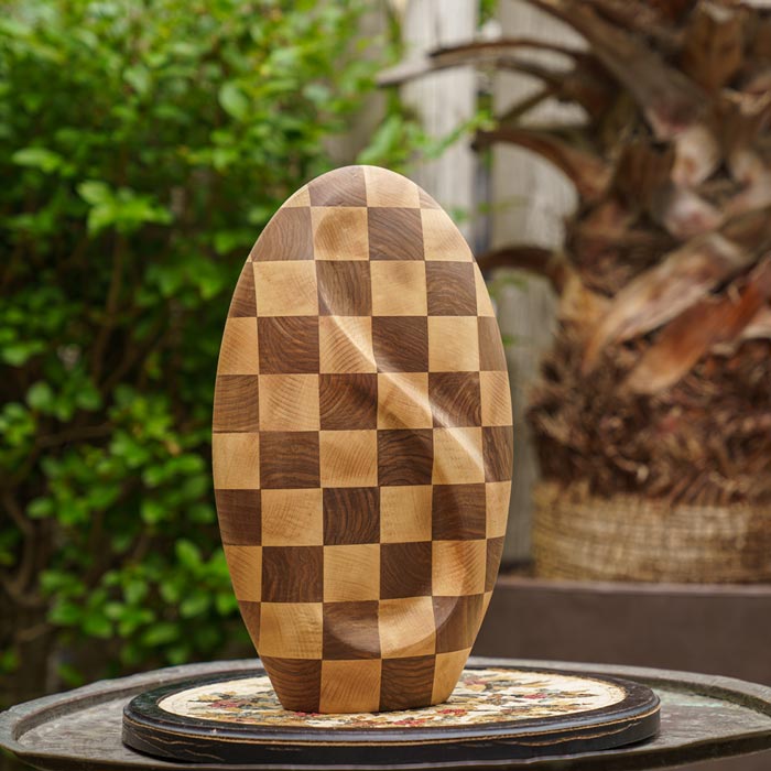 Infinity Wooden Adult Urn for Ashes Chequered Walnut and Beech Wood on Table in Garden