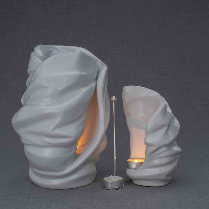 Light Cremation Urn and Ashes Keepsake Urn in White Turned Right with Candle Holder Dark Background