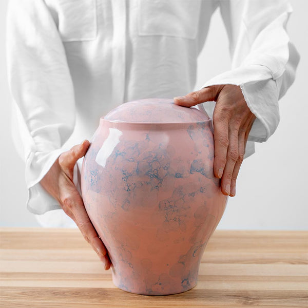 Pink Sky Classic Cremation Urn for Ashes Being Held