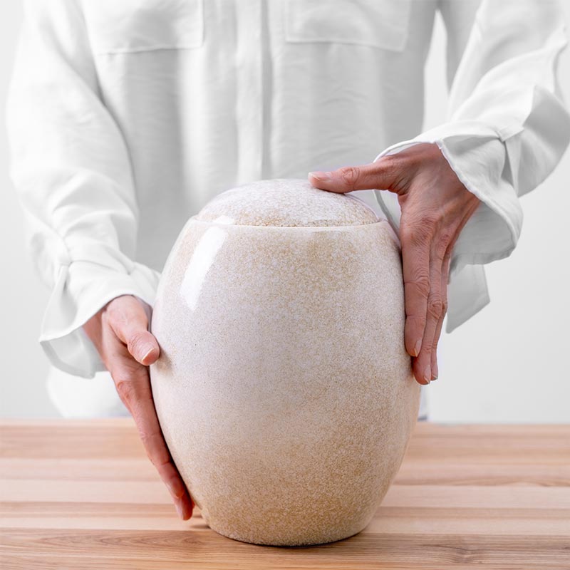 Sandy White Modern Cremation Urn for Ashes Being Held