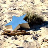 Star Ashes Miniature Keepsake Urn in Stainless Steel on Sand