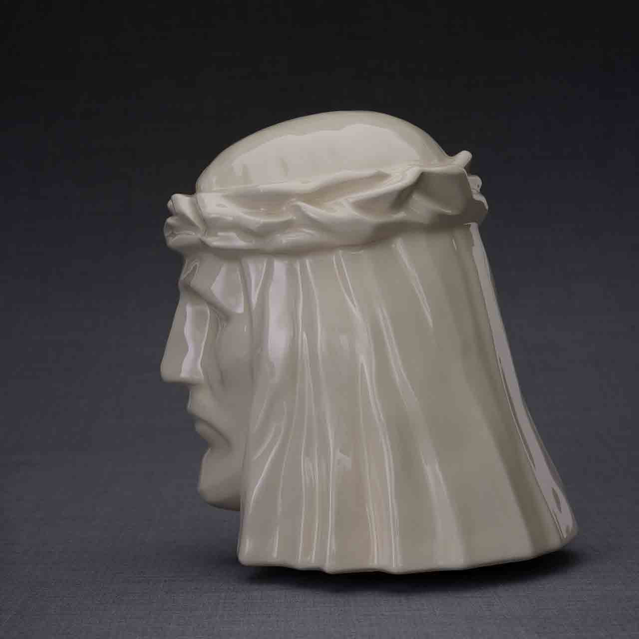 The Christ Cremation Urn for Ashes in Cream Facing Left Dark Background