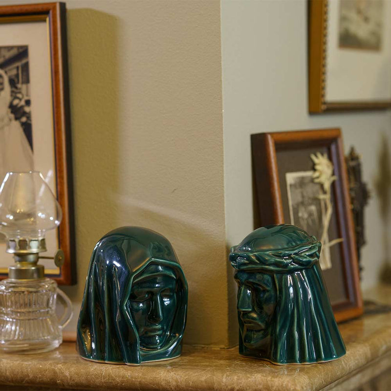 The Holy Mother Ashes Keepsake Urn with The Christ Ashes Keepsake Green on Fireplace