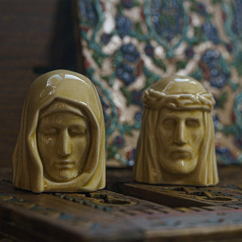 The Holy Mother Ashes Keepsake Urn with The Christ Ashes Keepsake Light Sand on Table
