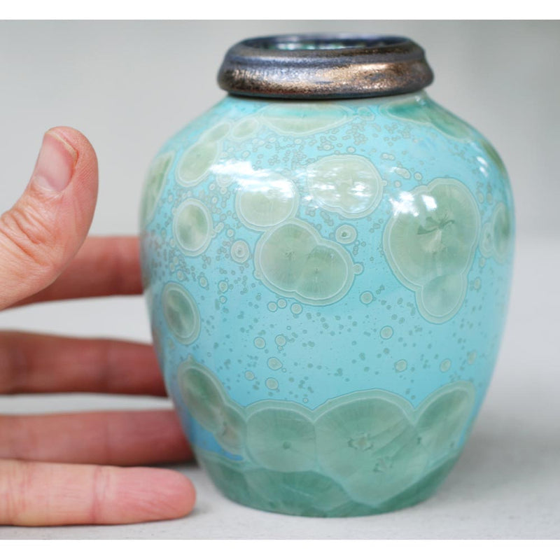 Turquoise Ashes Keepsake Urn Close up with Hand